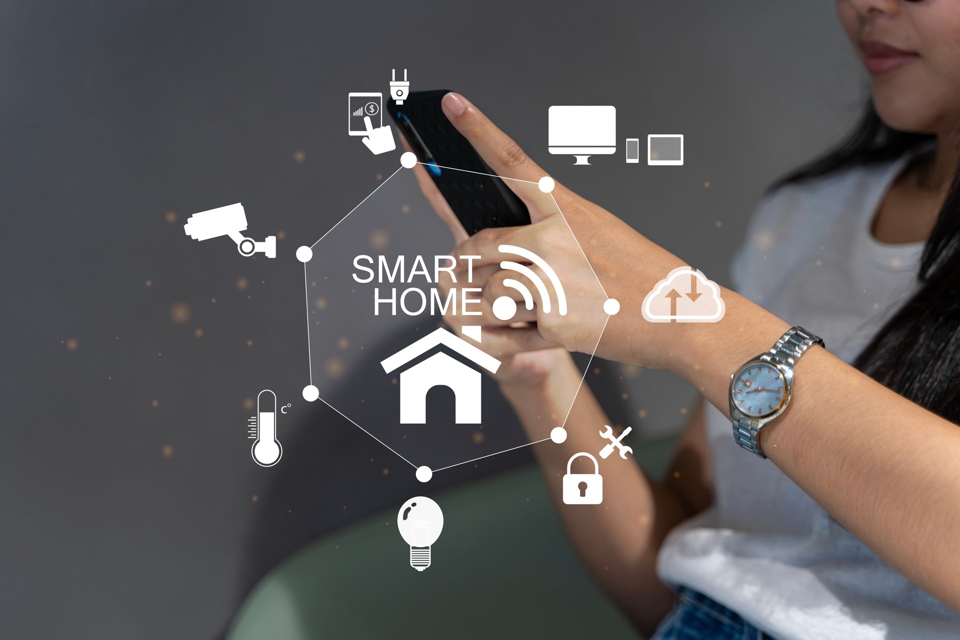 Woman's hands holding smartphone in bedroom with couple exposure of smart home interface, automation concept. Smart home automation control system.